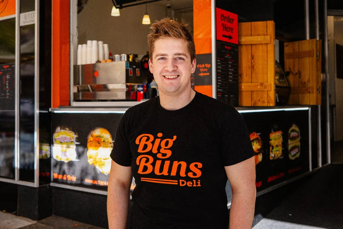 Chef Raphael Beilharz standing outside Big Buns Deli on Murray Street in a Big Buns Deli tee