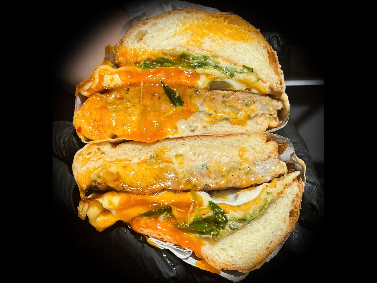 Sausage, Egg and Cheese sandwich: fennel and garlic sausage patty, fried egg, Swiss and buffalo sauce on a sesame brioche
